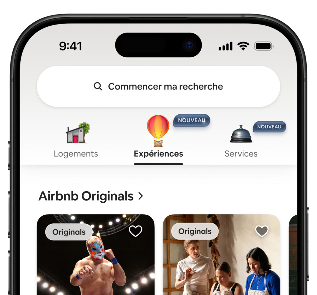 Capture d’écran de l’application mobile Airbnb en français, affichant la barre de recherche « Commencer ma recherche » en haut, et trois onglets de navigation : « Logements », « Expériences » (sélectionné), et « Services », ces deux derniers marqués comme « NOUVEAU ». En dessous, une section « Airbnb Originals » présente des vignettes d’expériences, dont un catcheur masqué sur scène et un atelier culinaire avec trois personnes.